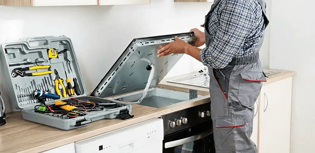 Handyman repairing a cooktop and checking wiring connections in Wichita, KS