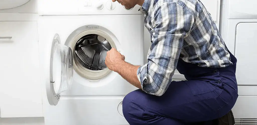Handyman inspecting a dryer drum and internal parts for repair in Wichita, KS