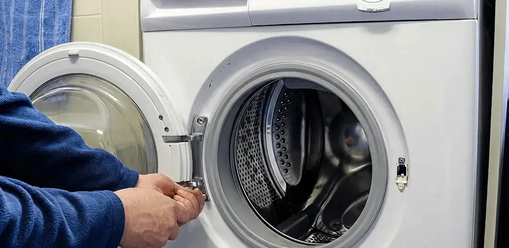 Washing machine repair handyman checking a front-load washer door and latch in Wichita, KS