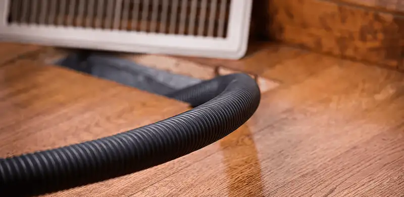 Air duct cleaning hose inserted into a floor vent for ductwork cleaning in Wichita, KS